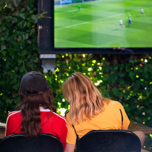 Two people sat watching a football game on the screen in our Courtyard arch