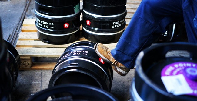 A brewer rolls a keg of Five Points beer in Hackney, London